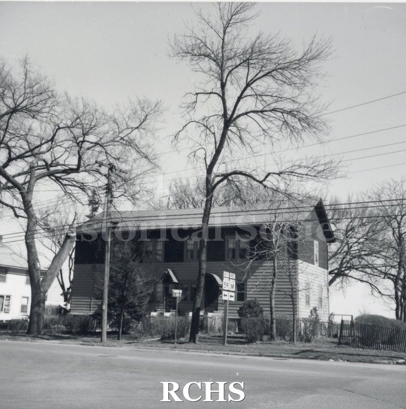 Black and white photograph of Socwell Apartments, a two story building with a sign in front for Highway 59 and M.