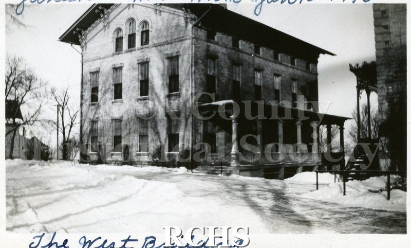 Black and white photograph of the Wisconsin School for the Blind, The West Building, is a three story building with snow on the ground. On top: "Janesville, Wis.
