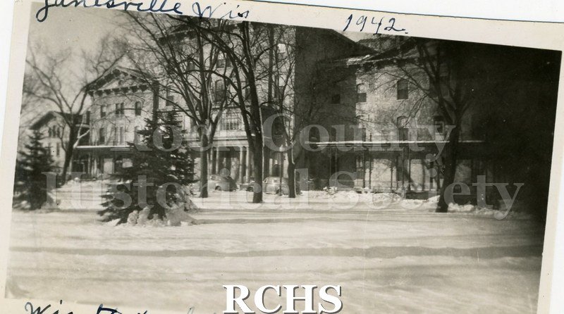 Black and white photograph of the Wisconsin School for the Blind, a three story building with extensions. There is snow on the ground. On top: "Janesville, Wis.