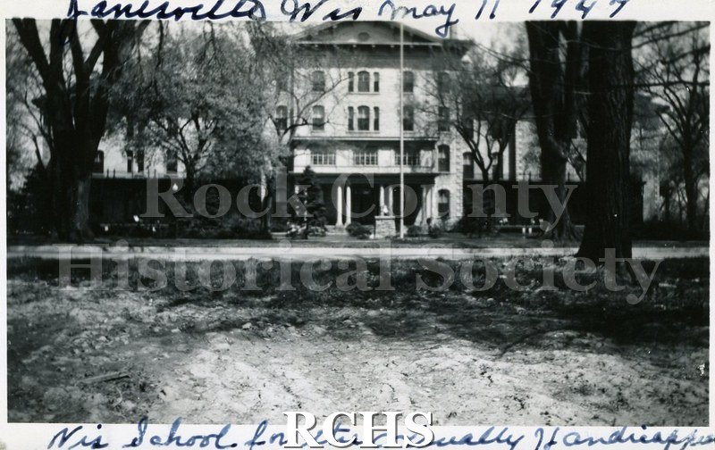 Black and white photograph of the Wisconsin School for the Visually Handicapped, a four story building with a pillared porch. On top: "Janesville, Wis.