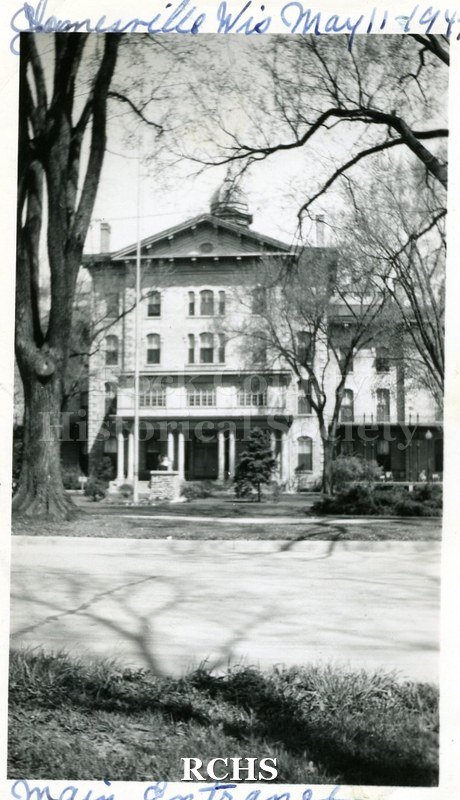 Black and white photograph of the Wisconsin School for the Blind main entrance in a four story building with a pillared porch. On top: "Janesville, Wis.