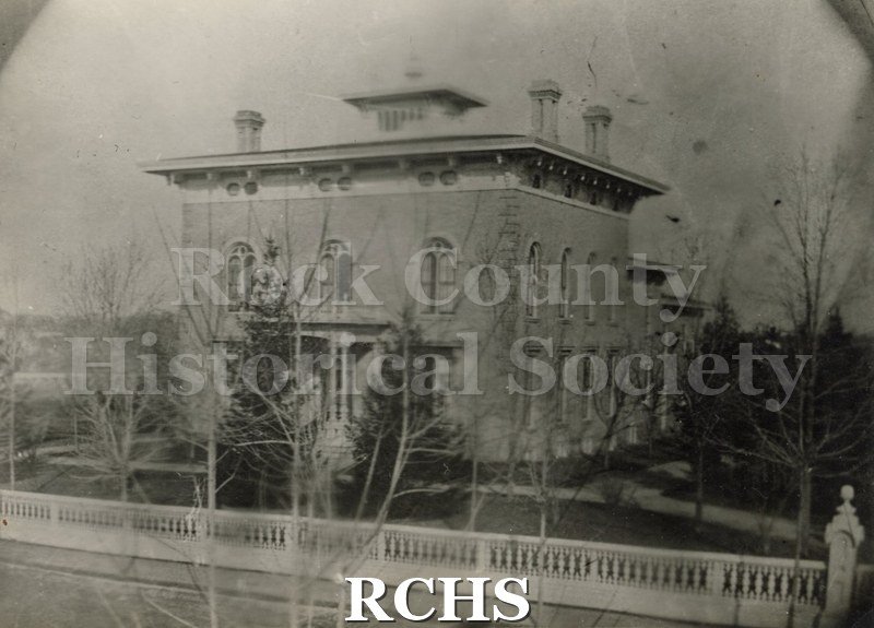 Black and white photograph of the Tallman House, front view. Shows bare trees and fence in front.