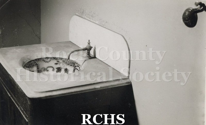 Black and white photograph of the Tallman House Lincoln bedroom lavatory. Shows the wash basin with a painted bowl and single faucet.