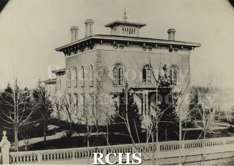 Historic image of Black and white copy print of the Tallman House showing fence in front. On bottom: "Tallman Homestead in the 1870's" GKT.