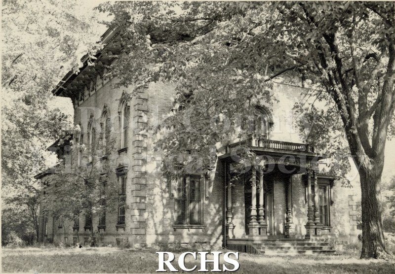 Black and white photograph of the Tallman House from the front with trees in front.