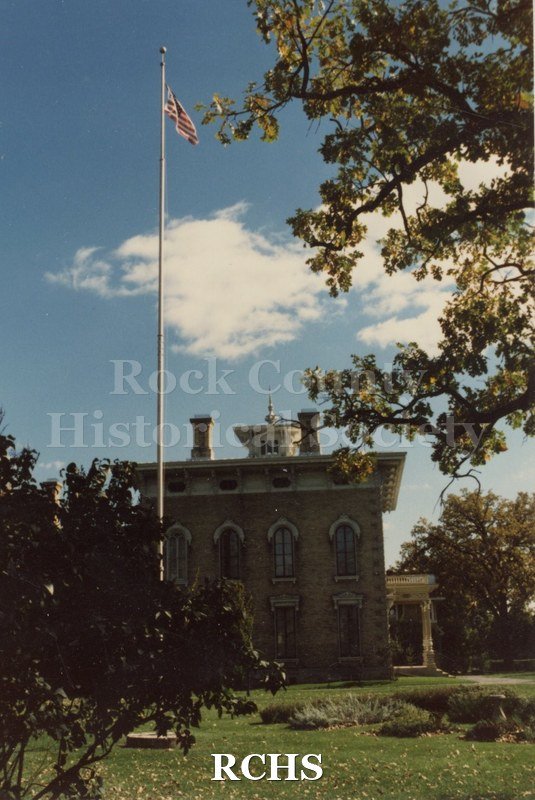 Colored photograph of the Tallman House with the flagpole in the front.