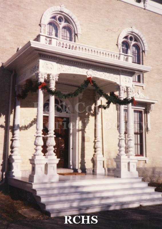 Color photo of the porch at the Tallman House decorated for Christmas.
