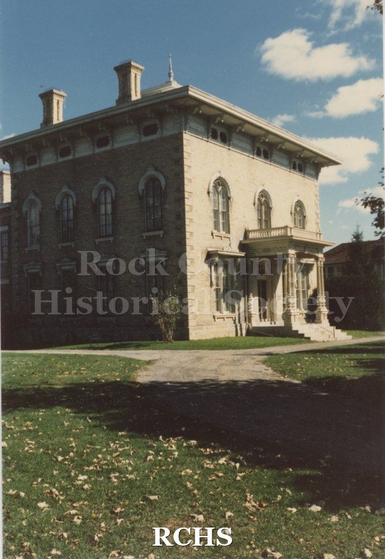 Color photo of the Tallman House from the front with shadows in the foreground.