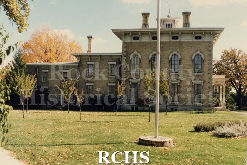 Color photo of the Tallman House from the south side. Shows the flagpole in the foreground.