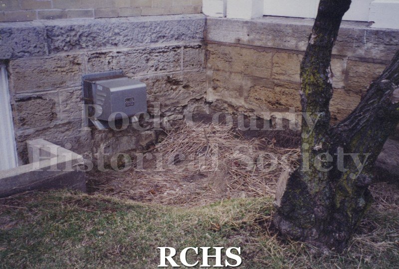 Color photo of the outside of the Tallman House showing the foundation.