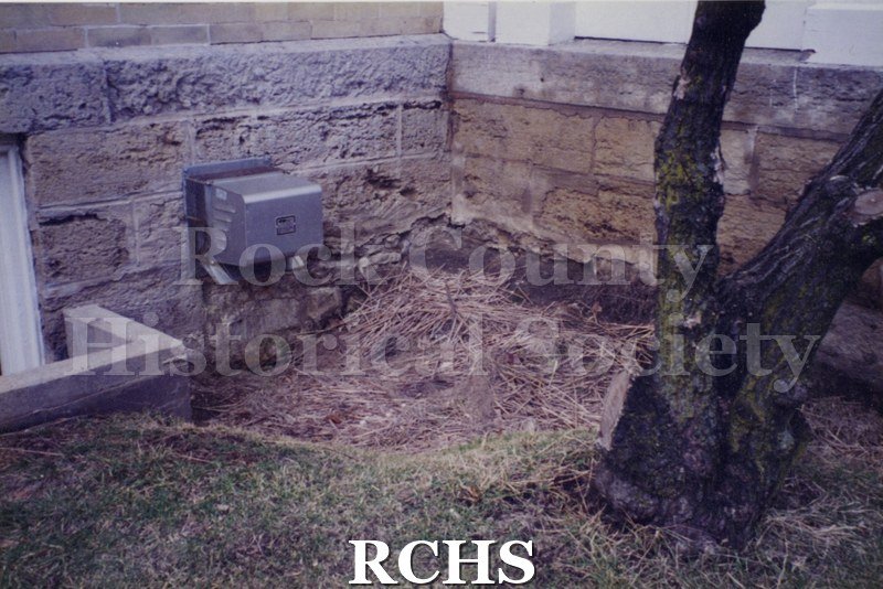 Color photo of the outside of the Tallman House showing the foundation.