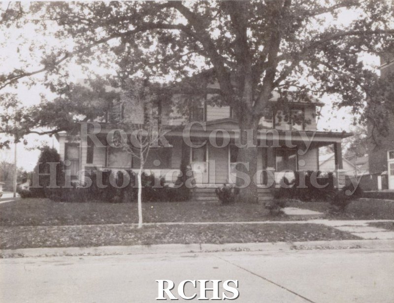 Black and white photograph of 168-170 S. Academy St., a two story house with double doors and a porch along the front of the house.