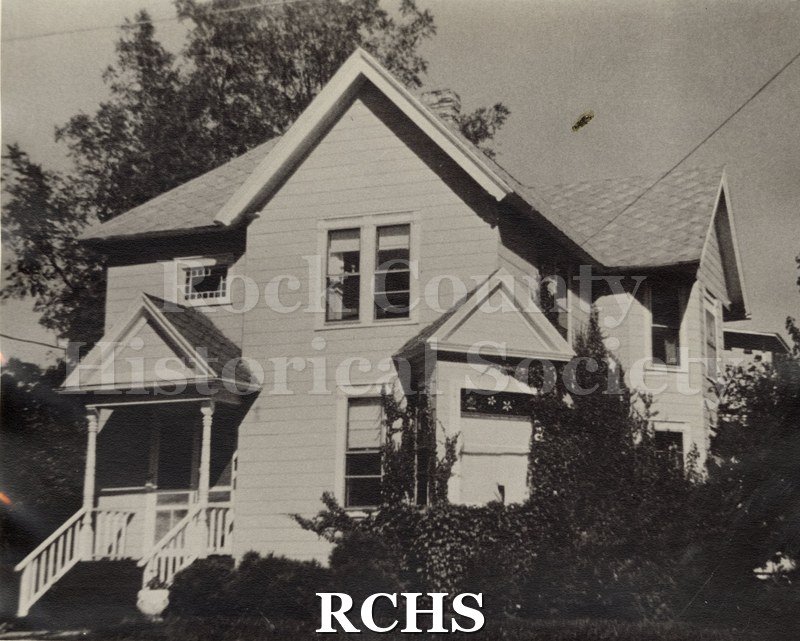 Black and white photograph of 17 Sinclair, Janesville, WI, a two story house with a peaked roof and a porch on the front.