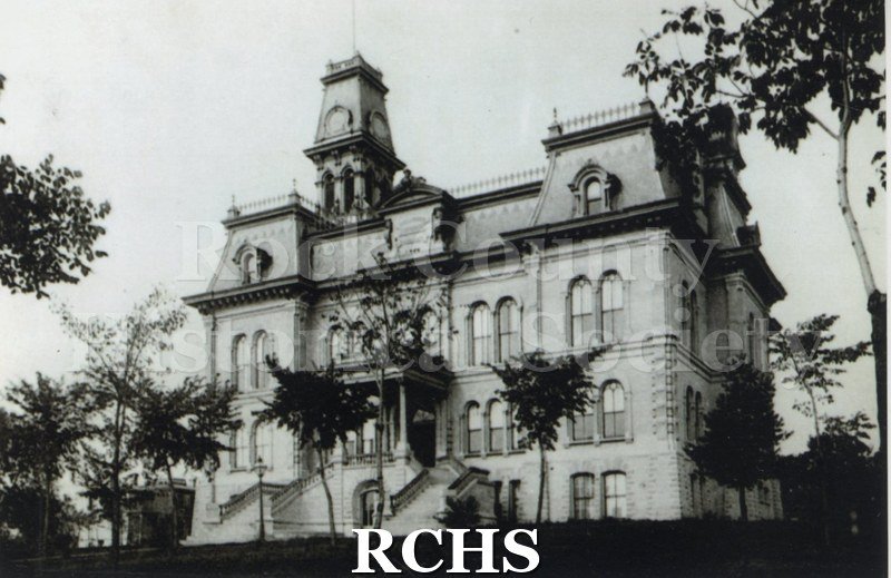 Black and white photograph of the Rock County Court House surrounded by trees.