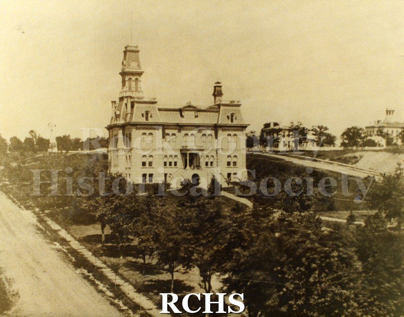Historic image of Sepia toned copy print of the Rock County Court House surrounded by trees.