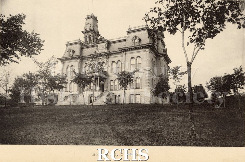 Black and white photograph of the Rock County Court House with several small trees.