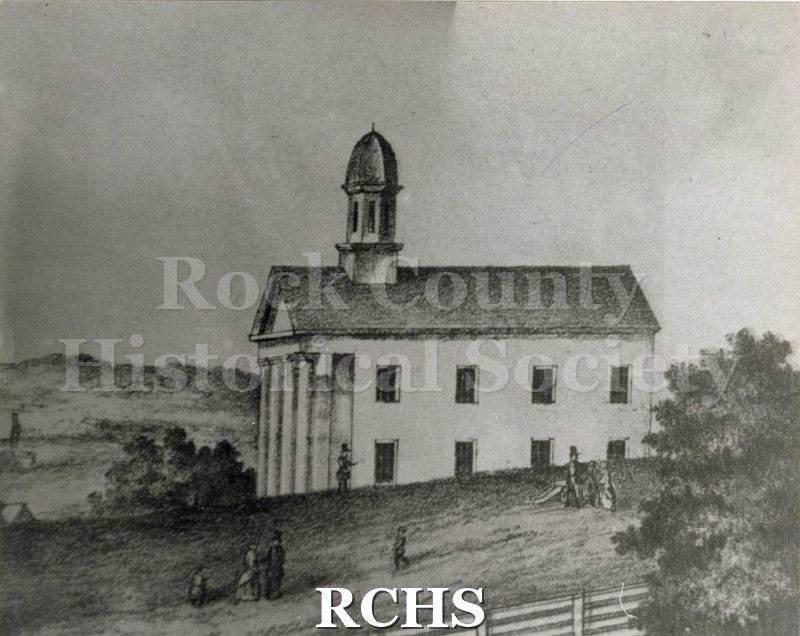 Historic image of Black and white lithograph of the Rock County Courthouse. Shows people walking beside it.