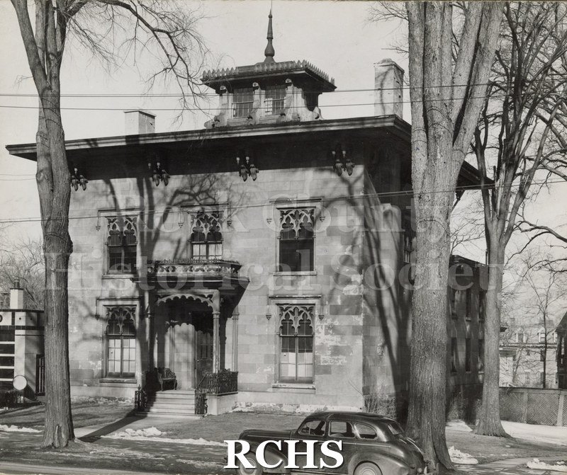 Black and white photograph of George Clinton Tallman residence, Utica, New York. Shows a two story house with a cupola on top and a finial on top of it.