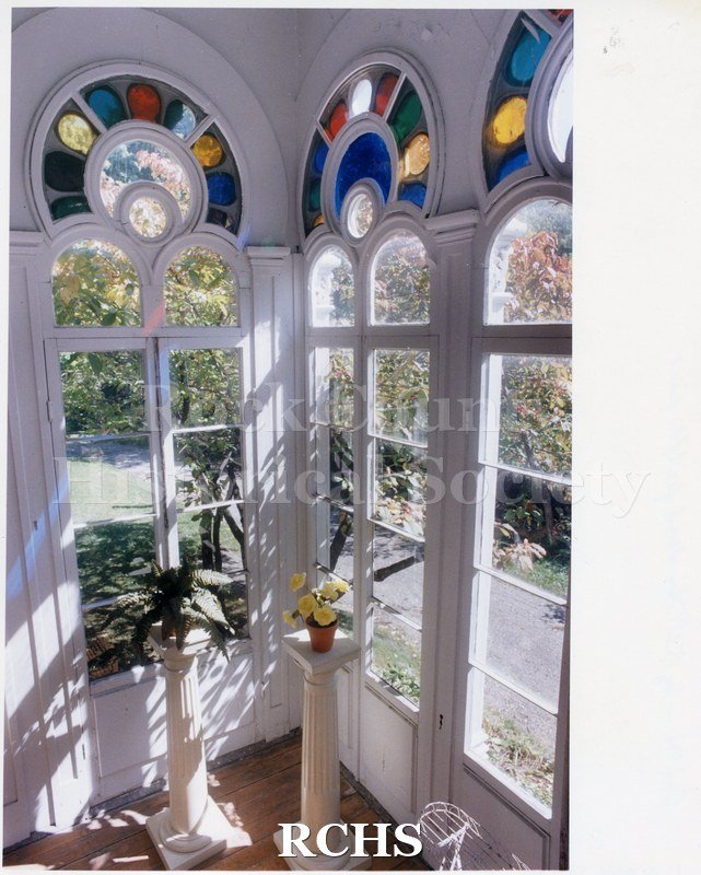 Historic image of Color photogrpah of the Atrium in the Tallman House showing three arched windows and the stained glass above them.