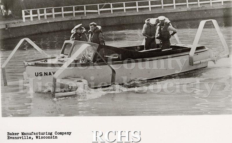 Black and white photograph of "High Pockets" in the water with four men aboard.