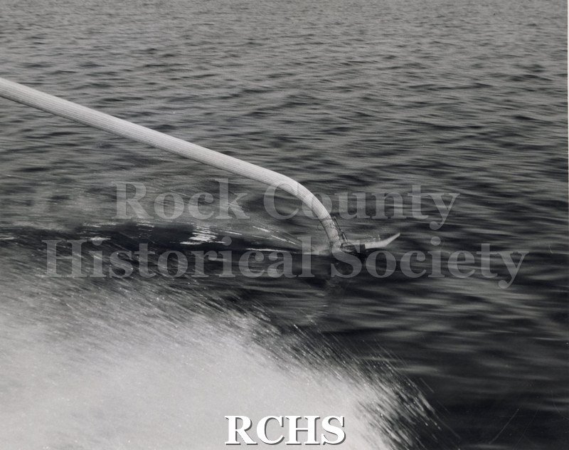 Black and white photograph of a close-up of ski in water from boat front on the"High Tail" hydrofoil. Photographer: "Black Photo Service 305 University Ave.