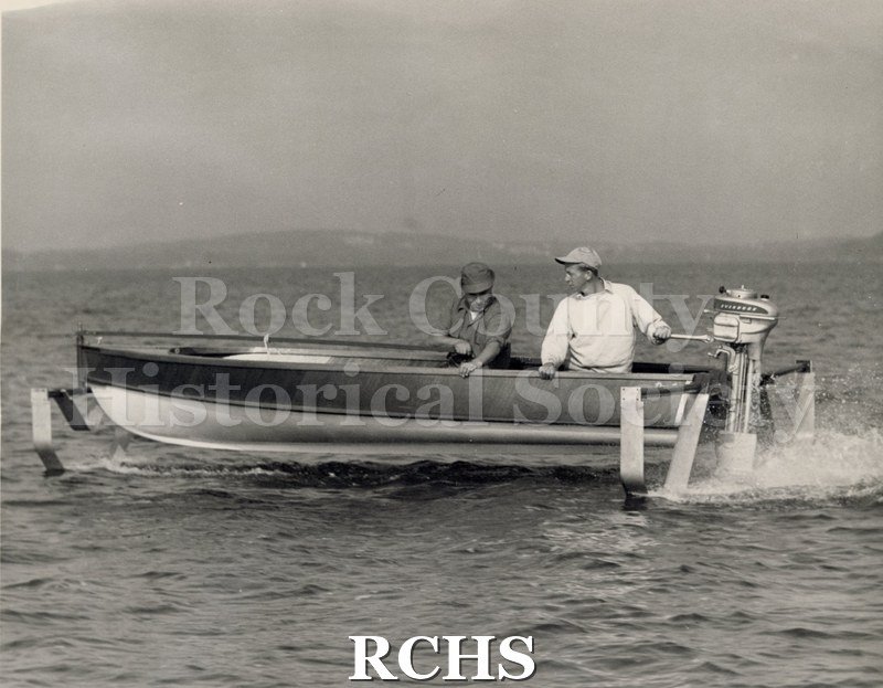 Black and white photograph of the first hydrofoil outboard with two men on board. On separate card: "1st hydrofoil outboard Wallace Olsen Warren Hull Late 1940's".
