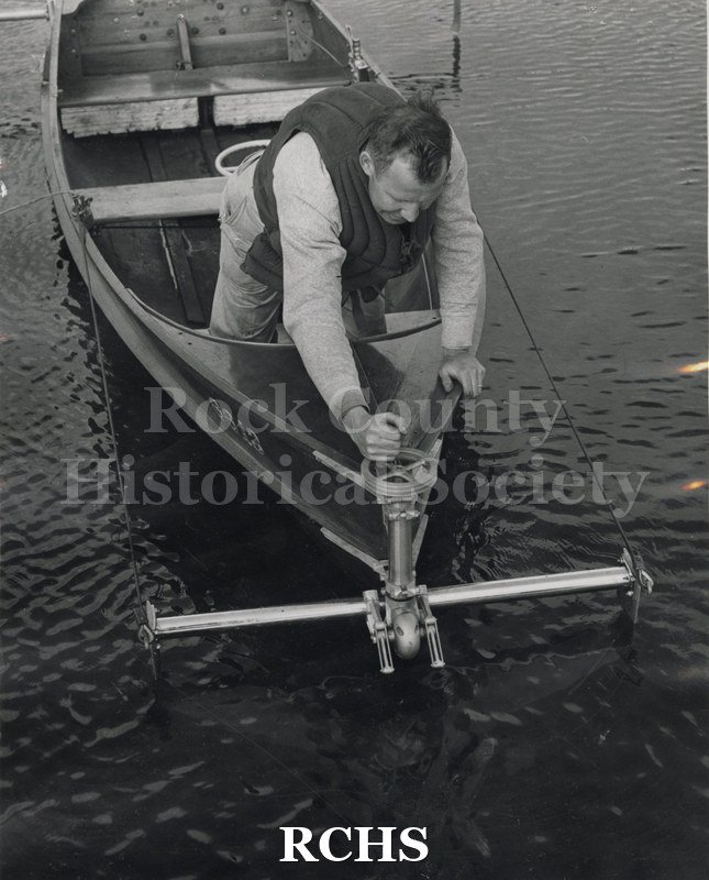 Black and white photograph of the front end of an outboard hydrofoil. Man in front is lowering the foil into the water. On separate card: "Max Palmer outboard HF".