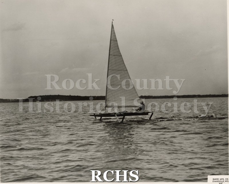 Black and white photograph of the Flying Sailboat-hydrofoil (U.S.Navy-Baker Manufactguring Co.) with one man aboard. On separate card: "J. G. Baker 16 Ft.