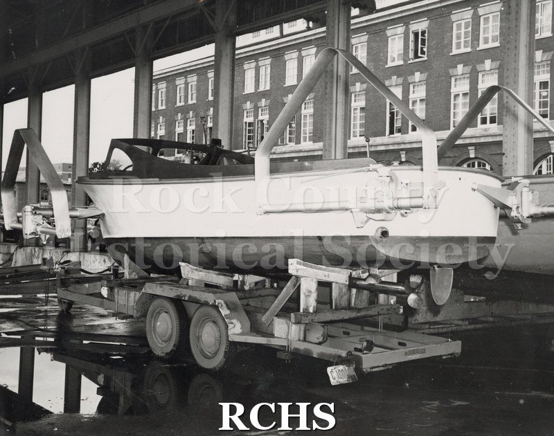 Black and white photograph of a Naval Boat on a wheeled trailer. (High Pockets) on a wheeled trailer.