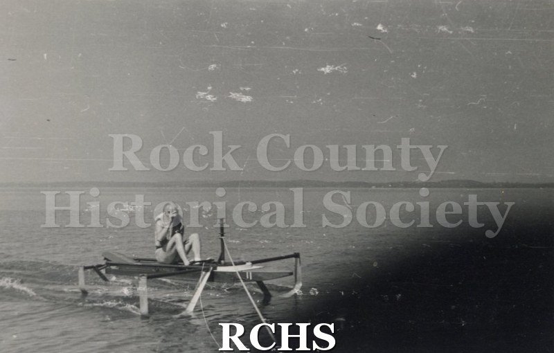 Black and white photograph of a stationary hydrofoil with a man sitting it it. Description given: "Foil testing-J. G.