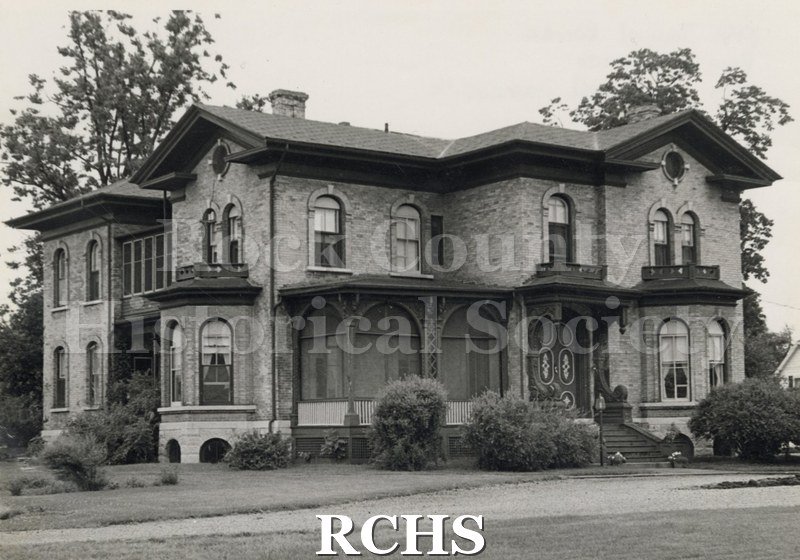 Black and white photograph of the Berg residence, a two story brick house.