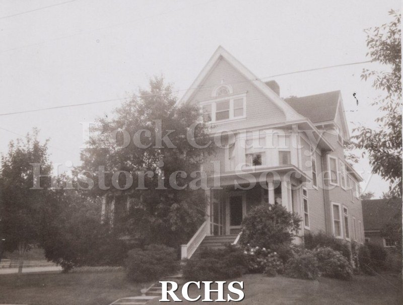 Black and white photograph of a three story house with a front pillared porch at 220 E.Holmes St.