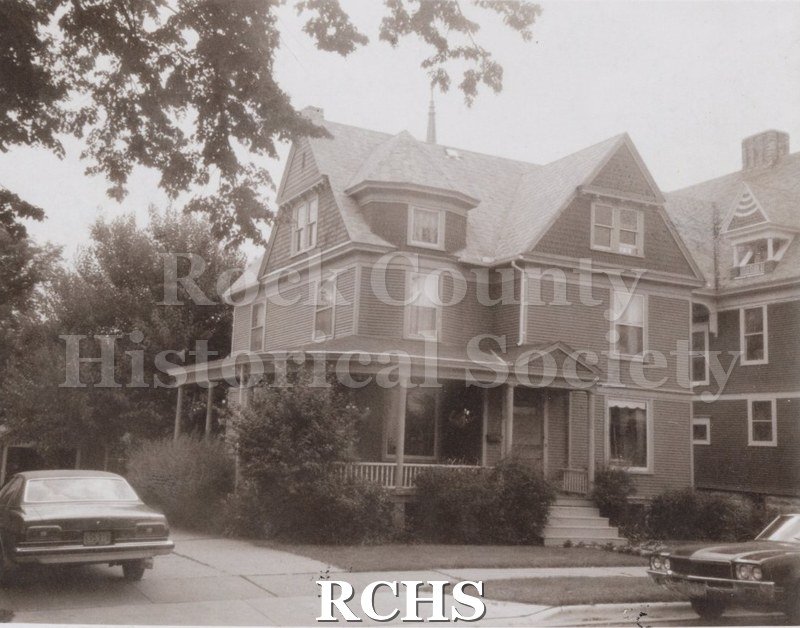 Black and white photograph of a three story house with a front and side porch at 21 N. Atwood.