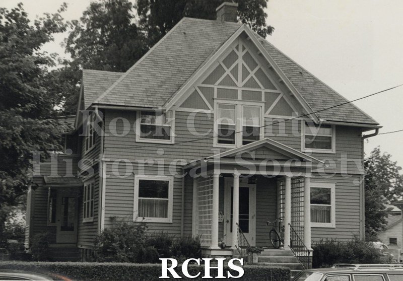 Black and white photograph of the Rydberg residence, a two story house with a small pillared porch on the front and a peaked roof.