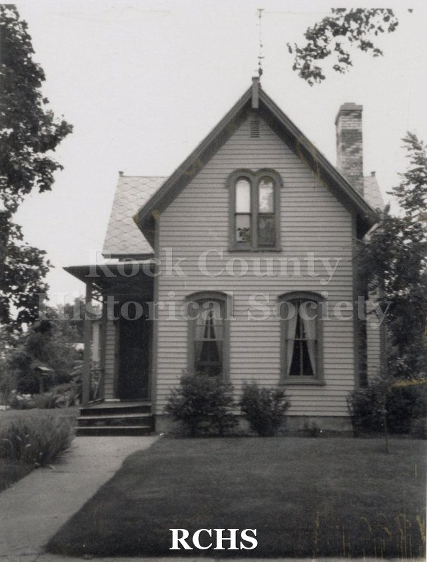 Black and white photograph of a two story house with two symmetrical windows on the first floor and a double window on the second floor at 303 Cornelia.