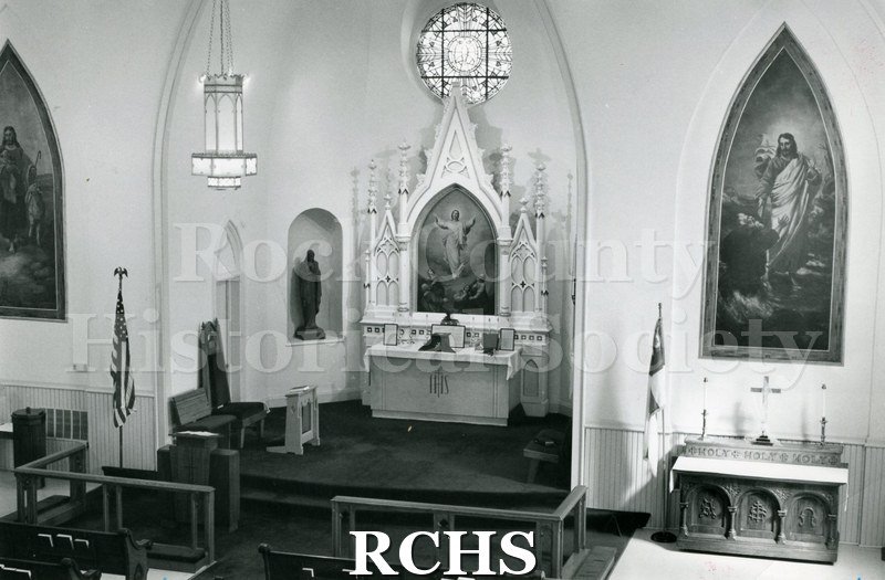 Black and white photograph of the interior of St. Paul's Lutheran Church, showing the altar and side pictures.