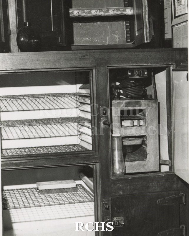 Black and white photograph of the Pliny Norcross-David Holmes residence. Shows the inside of a refrigerator with the door open.