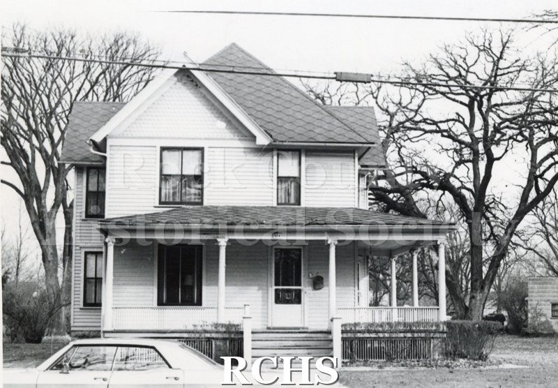 Black and white photograph of 514 Washington St., Janesville, WI (demolished). Shows a two story house with a porch along the entire front.