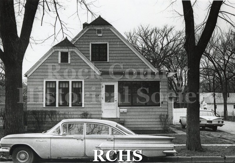 Black and white photograph of 519 Terrace St., Janesville, WI. Shows a two story house with shingle-type siding. There is an enclosed porch on the right.