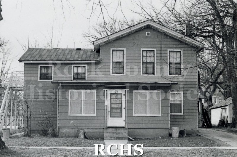 Black and white photograph of 525 N. River St., Janesville, WI, demolished c. July 1, 1971. Shows a two story house with an enclosed porch on the front.