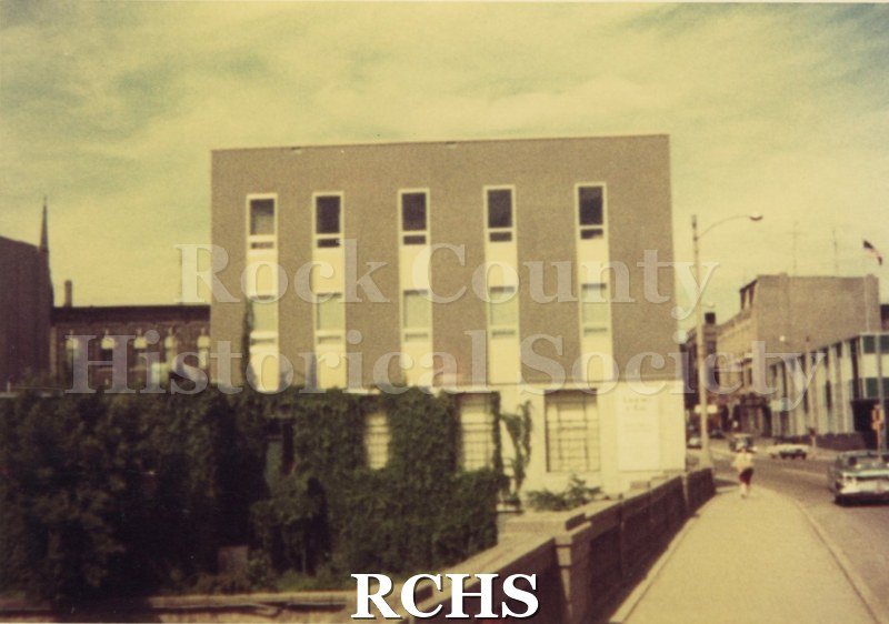 Color photo of an unidentified four story building with windows in columns.