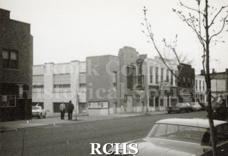 Black and white photograph of several stores in downtown Janesville. On the left is the Salvation Army and on the right is Larry's Vacuum.