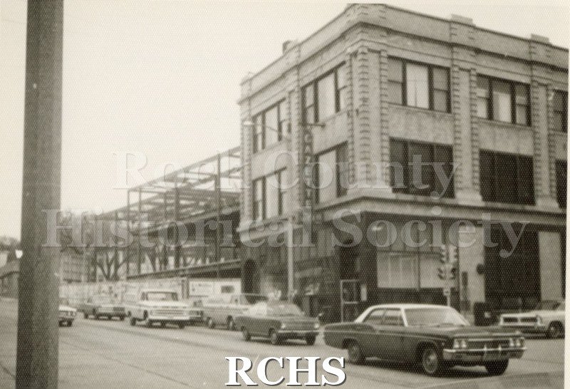 Black and white photograph of the Janesville Gazette Building. Shows a three story building with a sign for "Gazette" on it.