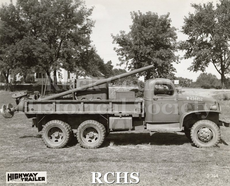 Black and white photograph of an Army truck from Highway Trailer Co., Edgerton, WI. Shows a truck with a screw device on a long pole in the back.