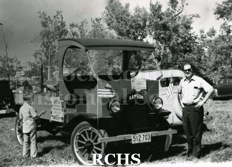 Black and white photograph of Richard Hartung standing beside a 1922 Samson truck with license 512-703.