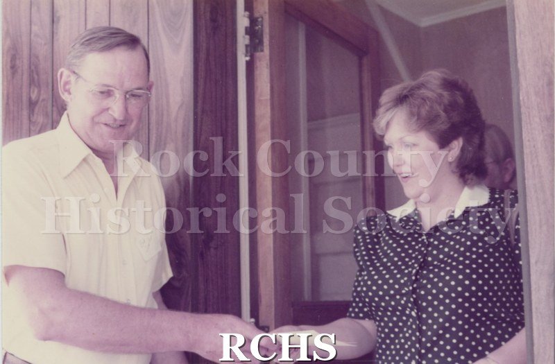 Historic image of Tinted photographof an unidentified house on the 1984 Janesville Historic House Tour. Shows a man and a woman standing in a room.