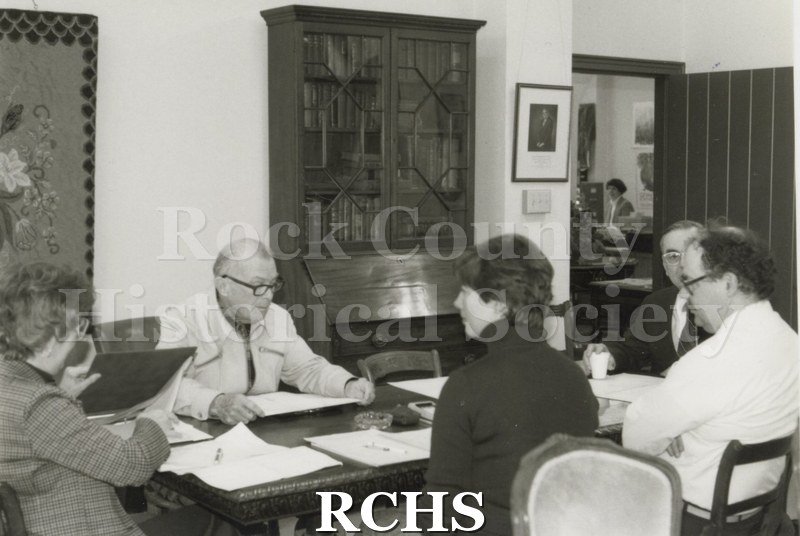 Black and white photograph of the budget committee sitting around a table in the Historical Society building.