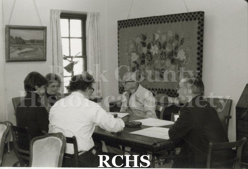 Black and white photograph of the budget committee sitting around a table in the Historical Society building.