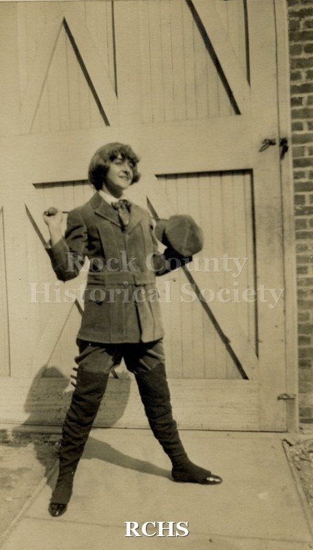 Color photo of Reba Tallman McCormick in role of Little Lord Fauntleroy. She is posed standing in front of a door.