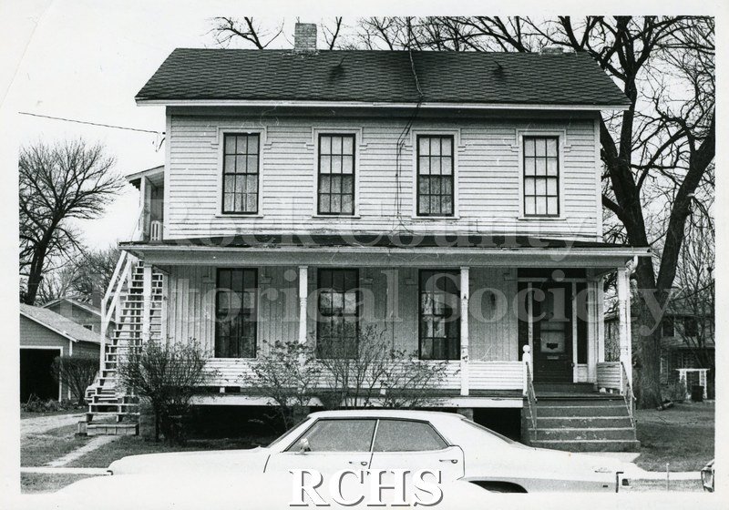 Black and white photograph of 539 Terrace Street, Janesville, WI. Shows a two story house with a porch along the entire front.